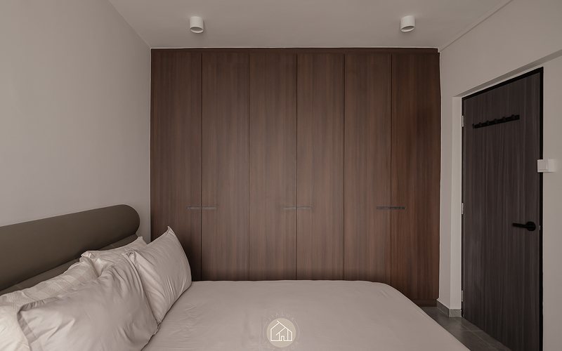 Floor-to-ceiling wood grain wardrobe creating spatial privacy in bedroom.