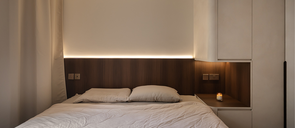 Minimalist bedroom with ambient headboard lighting for relaxation.
