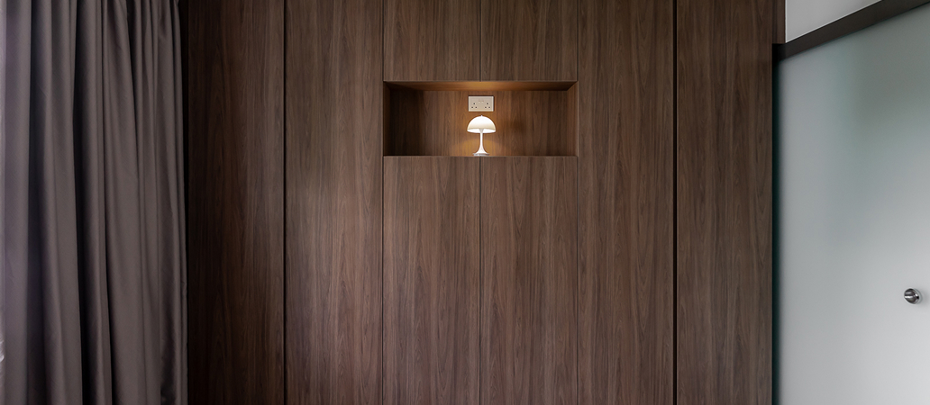 Full-height walnut cabinetry providing functional storage in a bedroom.